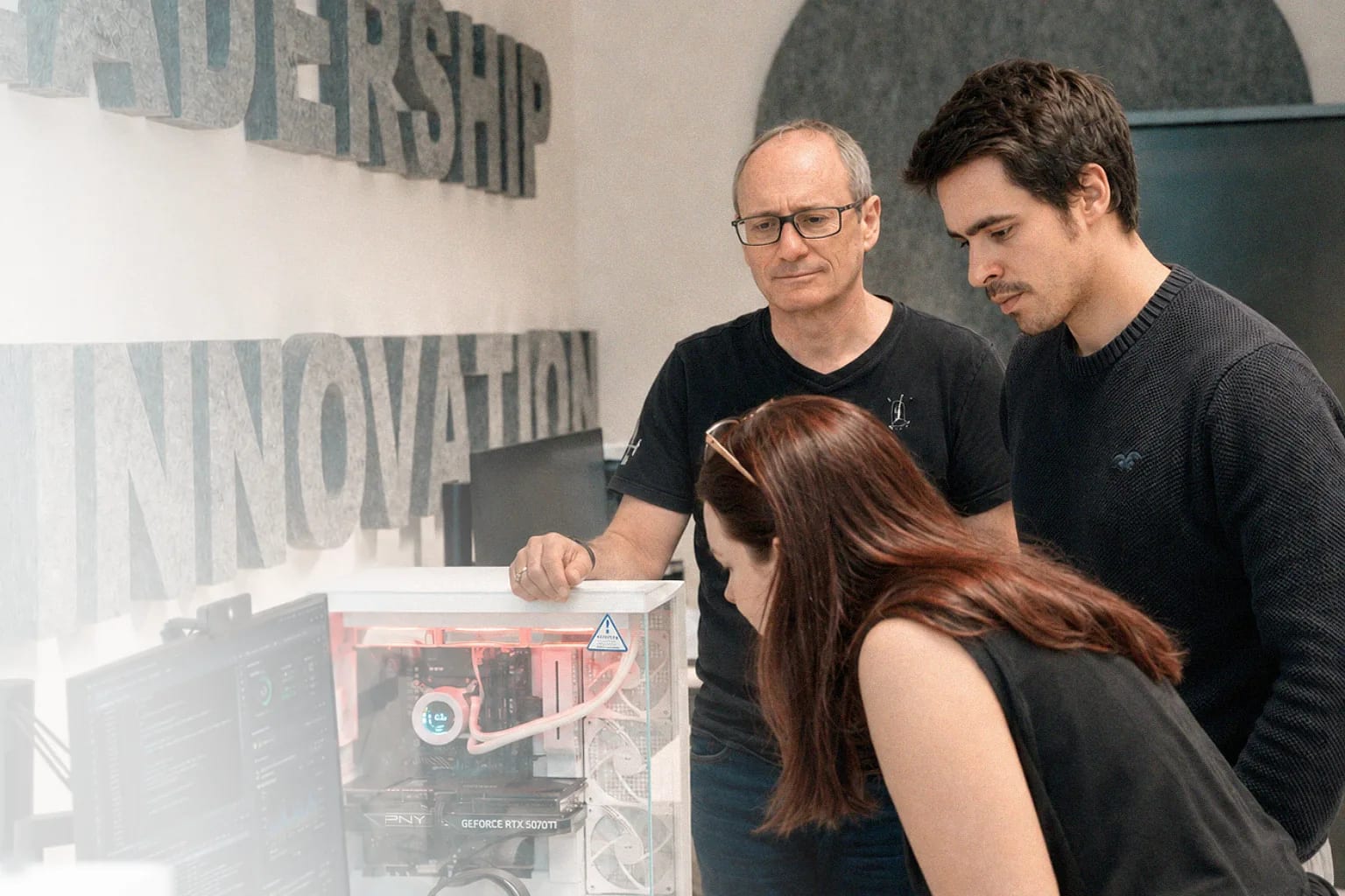 Trois membres de l’équipe Aliant réunis autour d’un poste informatique.